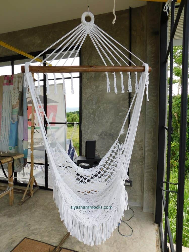 Bohemian white cotton hammock chair for indoor use, shown in a modern space with concrete finishes and a bright natural environment view.