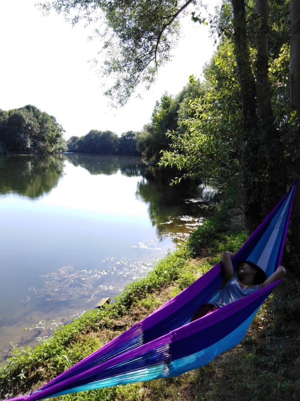 a girl in a hammock by the river