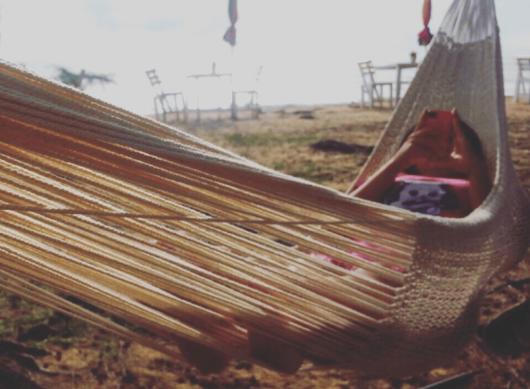 a girl in a white hammock on the beach