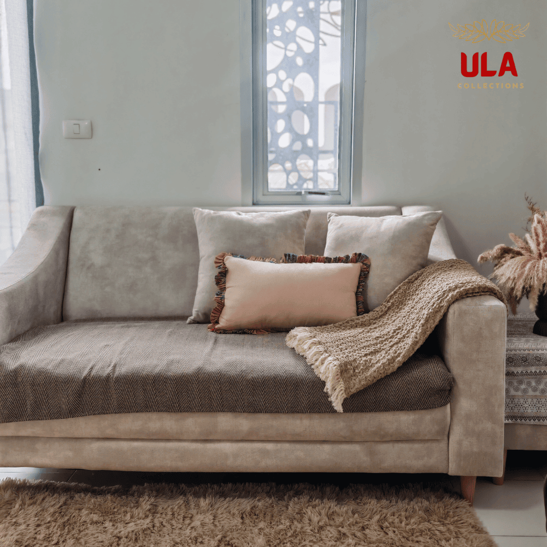 Almond ruffle blanket with fringe detail styled on a couch with decorative pillows