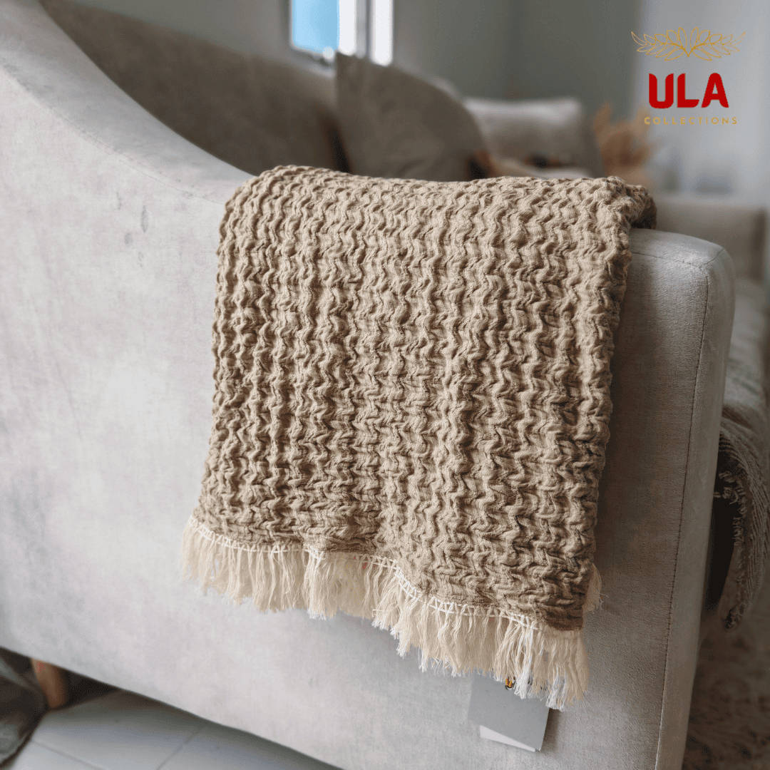 Close-up of the deep almond textured ruffle blanket folded over the arm of a couch