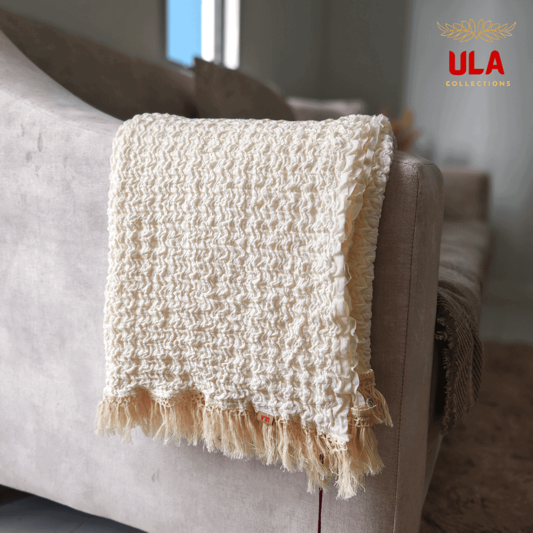 Close-up of the cream ruffle texture and fringe tassel detail on the throw blanket