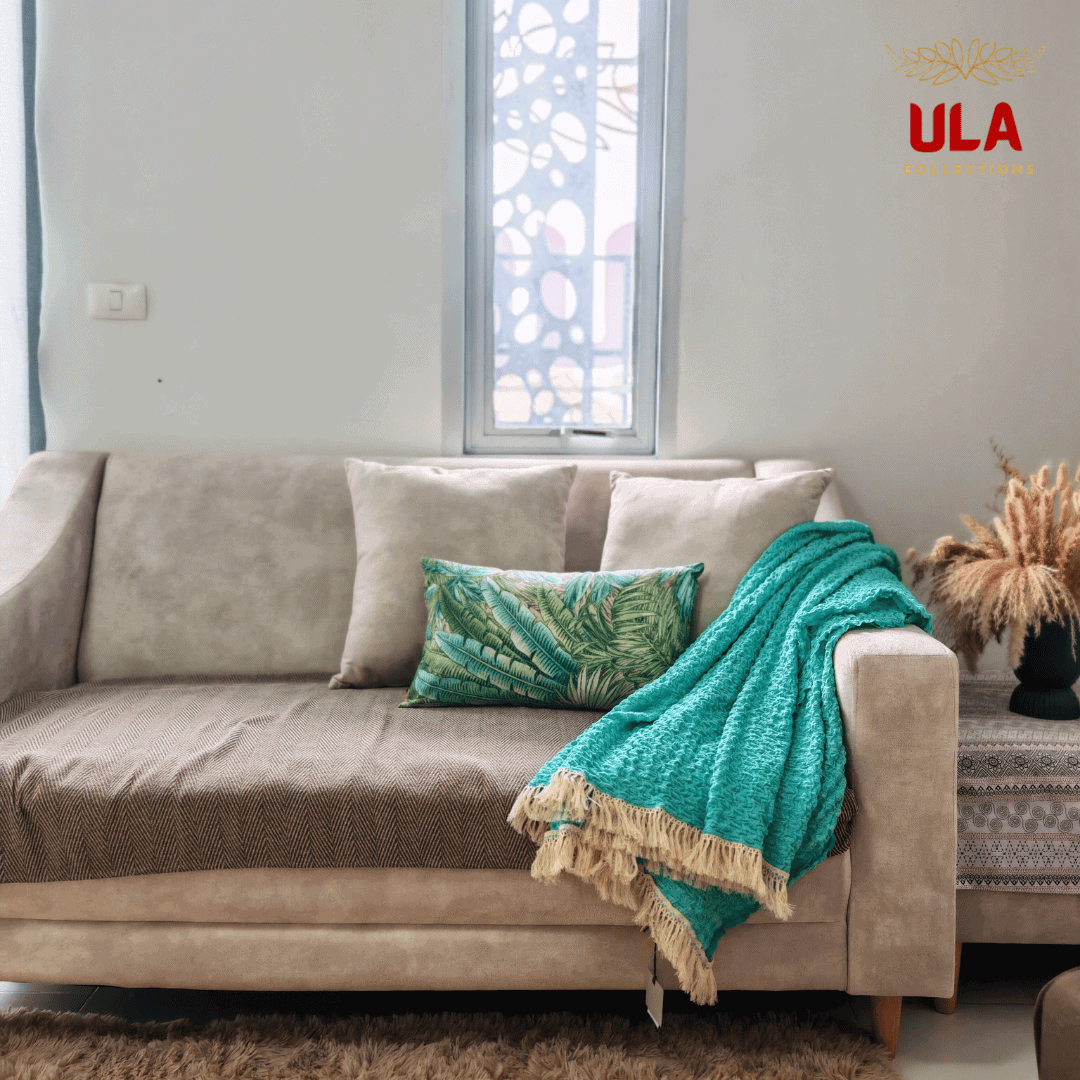 Turquoise ruffle throw blanket casually styled over the arm of a couch with pillows