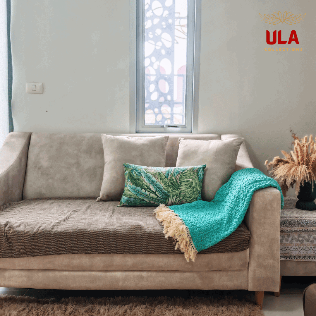 Turquoise ruffle throw blanket casually styled over the arm of a couch with pillows