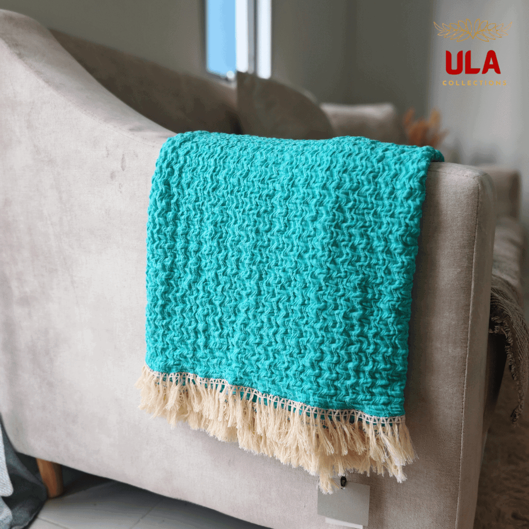 Close-up detail of the vibrant turquoise ruffle texture and light fringe on the throw